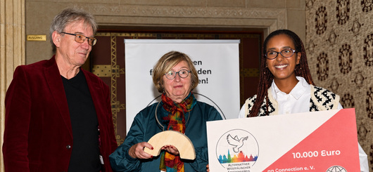 Rüdiger Sagel und Juliane Brüggemann überreichen Sarah Ghebremariam den Alternativen Westfälischen Friedenspreis.